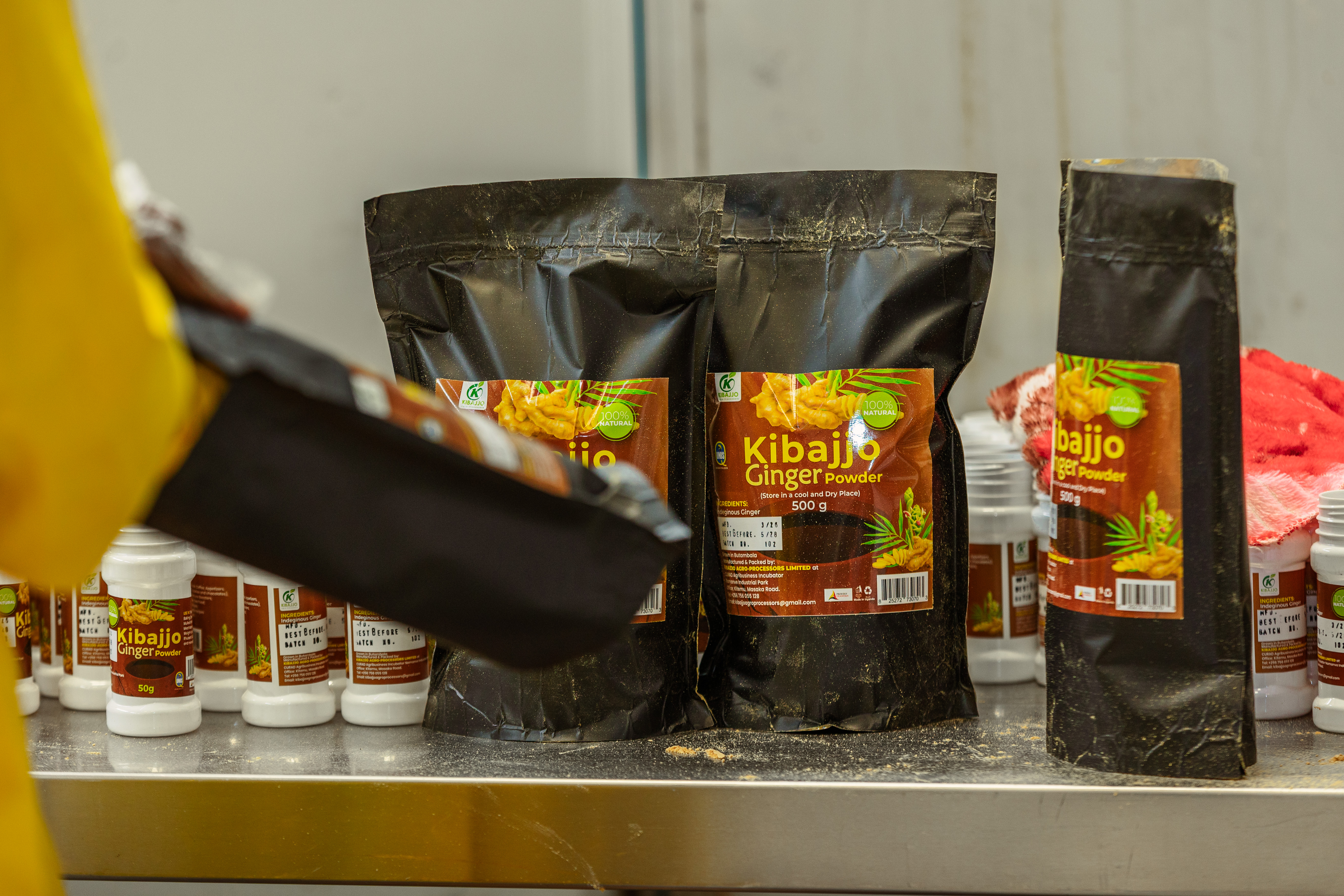 Kibajjo ginger powder pouches and shaker bottles arranged in the processing room
