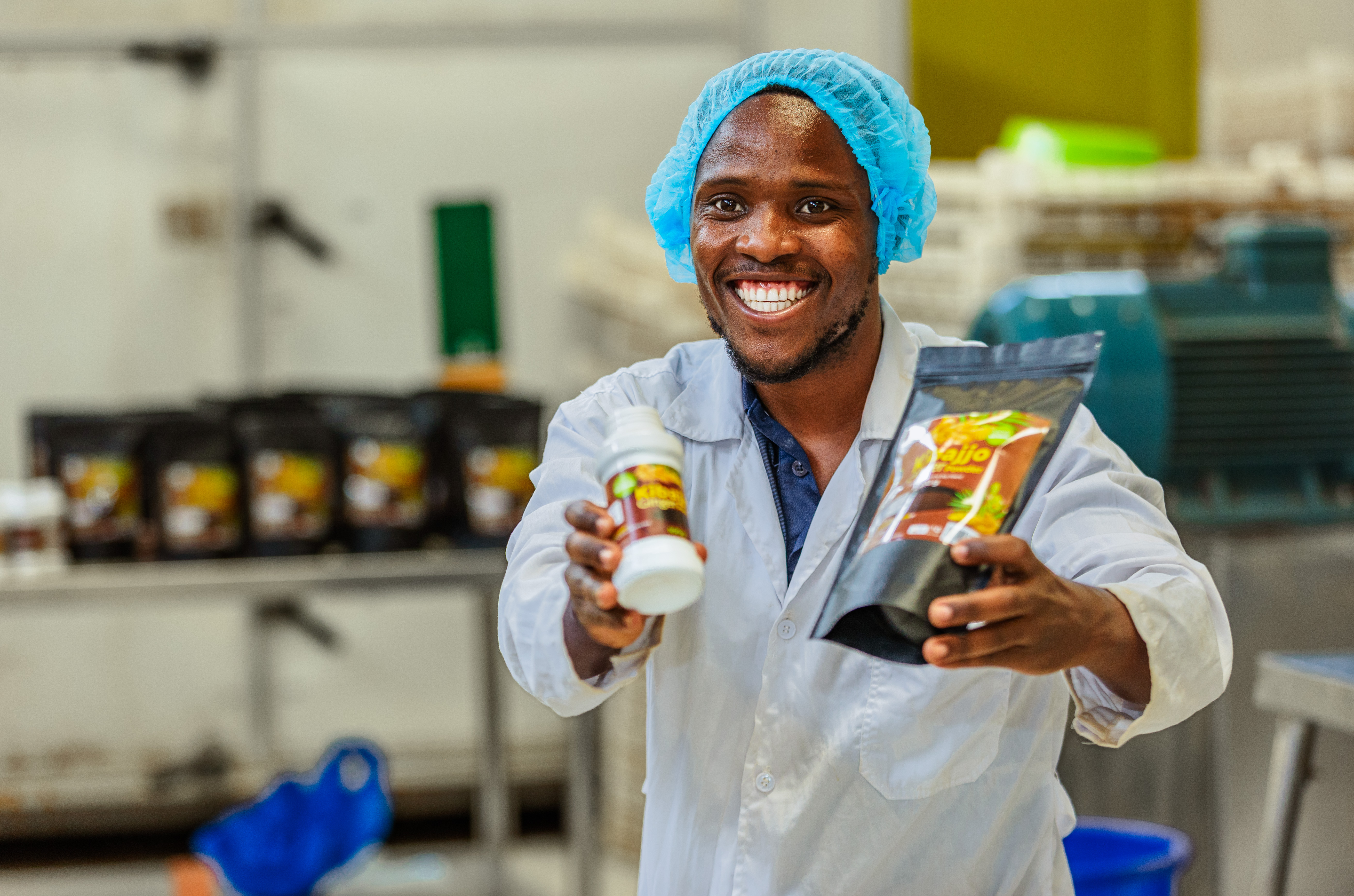 Kibajjo team lead holding finished ginger products in the processing room